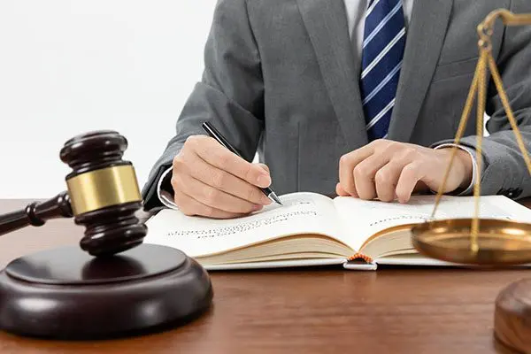 A man in suit writing on a book.