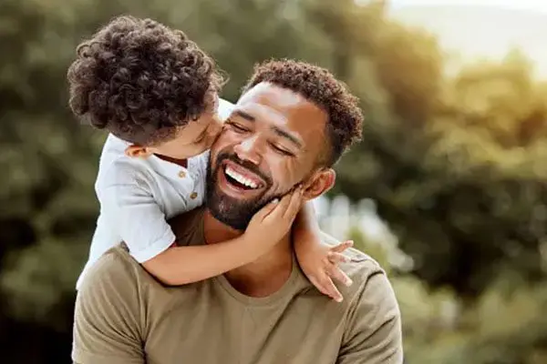 A man and his son are smiling for the camera.