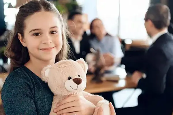 A girl holding a teddy bear in her hands.